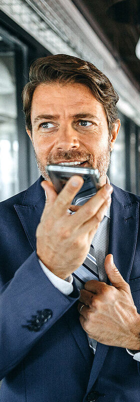 Seamless communication A man uses the MagentaONE Business voice control function on his smartphone for seamless communication.