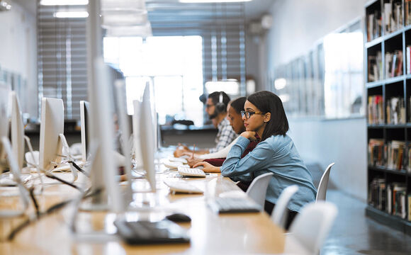 Students working with the campus network in a library