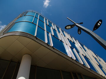 An office building with street lamps in the foreground reflected in the sunlight and visualizes sustainable digitalization solutions from T Business.