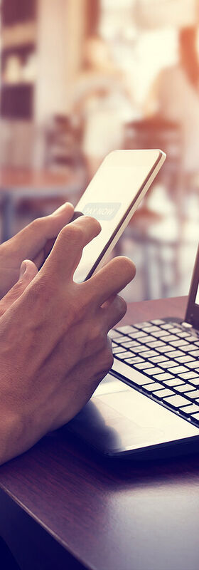 The hand of a man using his smartphone for online payments as an example of the digital transformation of government