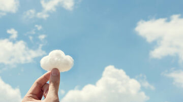 Cloud migration A cotton wool cloud is held in front of a blue sky with clouds and symbolizes cloud migration, a T Business solution.