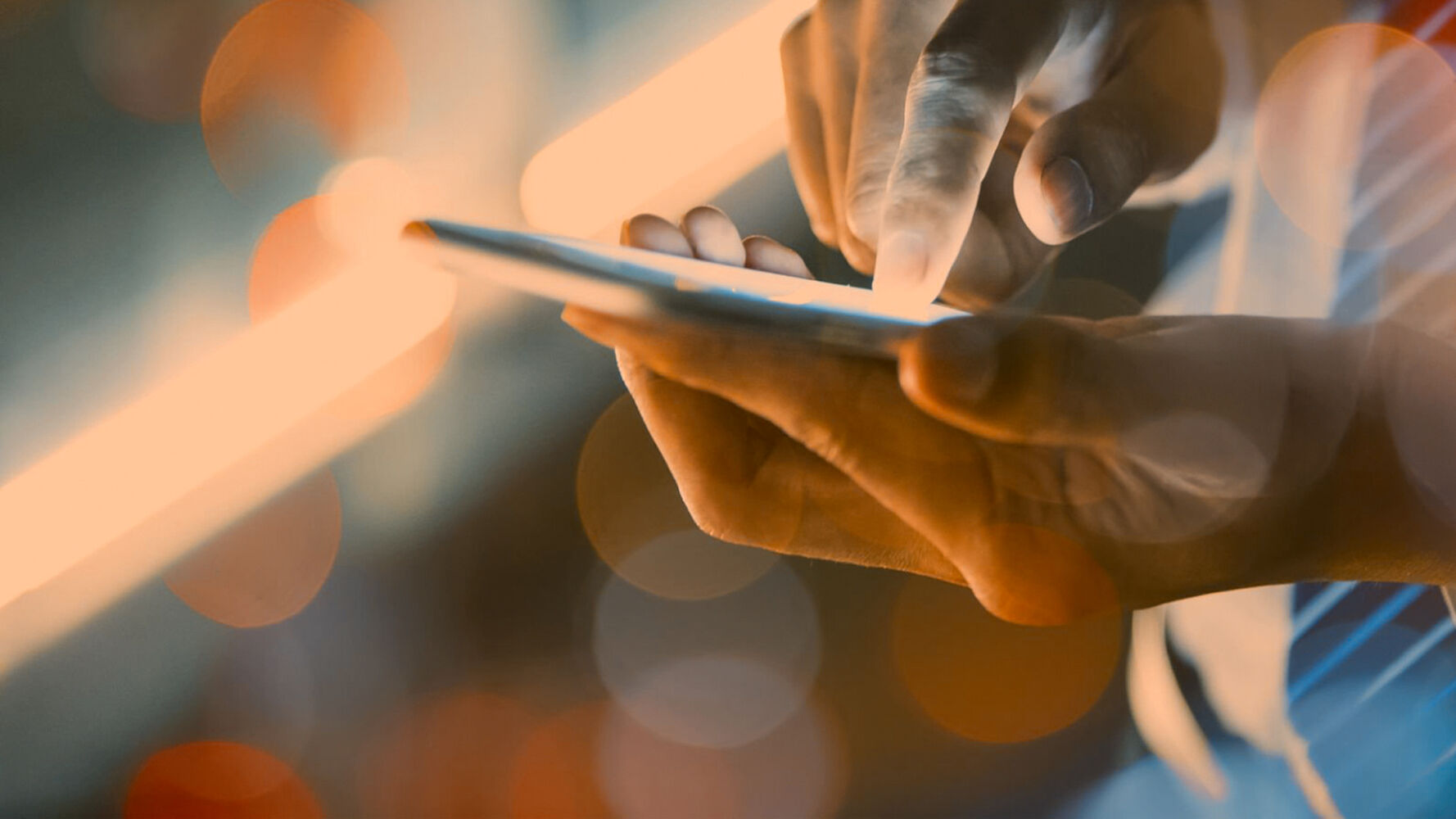A person holding a smartphone in one hand and with the other typing on the mobile phone.