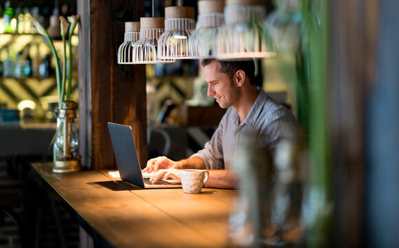 Happy business man working at a cafe and using free wifi | T Business