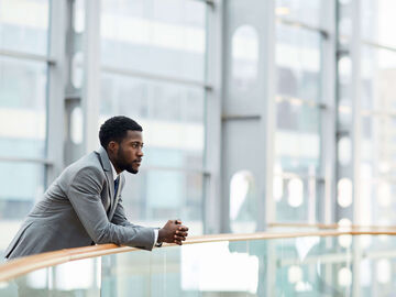 Hospitality IT Solutions A man standing in a lobby of a hotel, that uses the best hospitality IT solutions