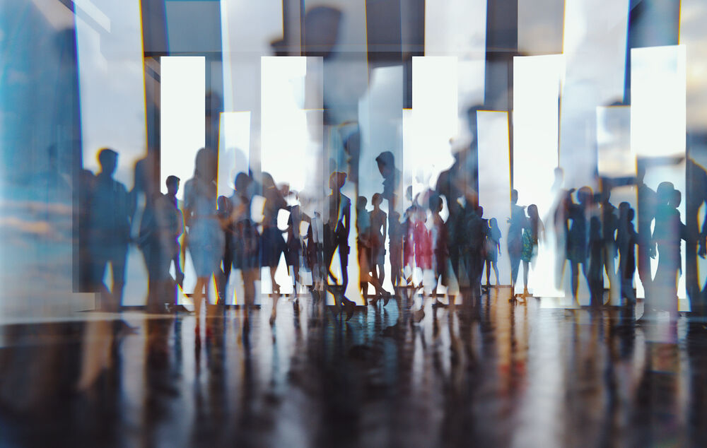 Abstract silhouettes of people in front of glass talking about IT solutions for the public sector