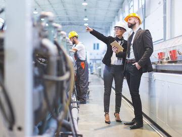 Workers in a factory discussing banking and financial solutions