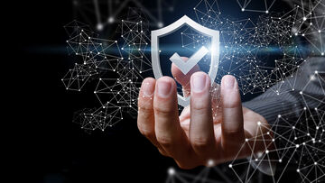 Security risks A hand holds up a symbolic shield, symbolizing the full security assessment with T Business solutions that identify security risks.