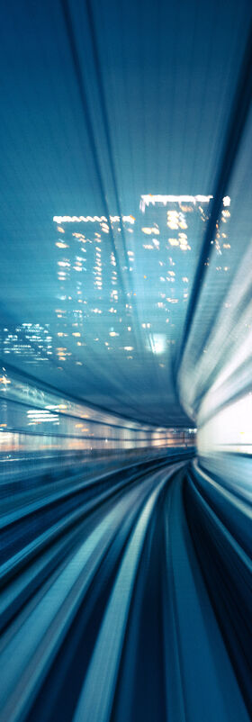 An abstract and motion-blurred view from the cockpit of a train in a smart city