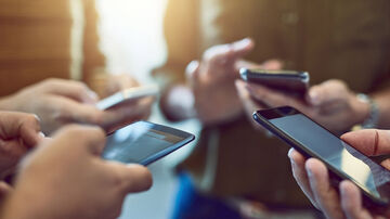 Fast internet connection A group of individuals with smartphones are utilizing the secure and fast internet connection provided by T Business.