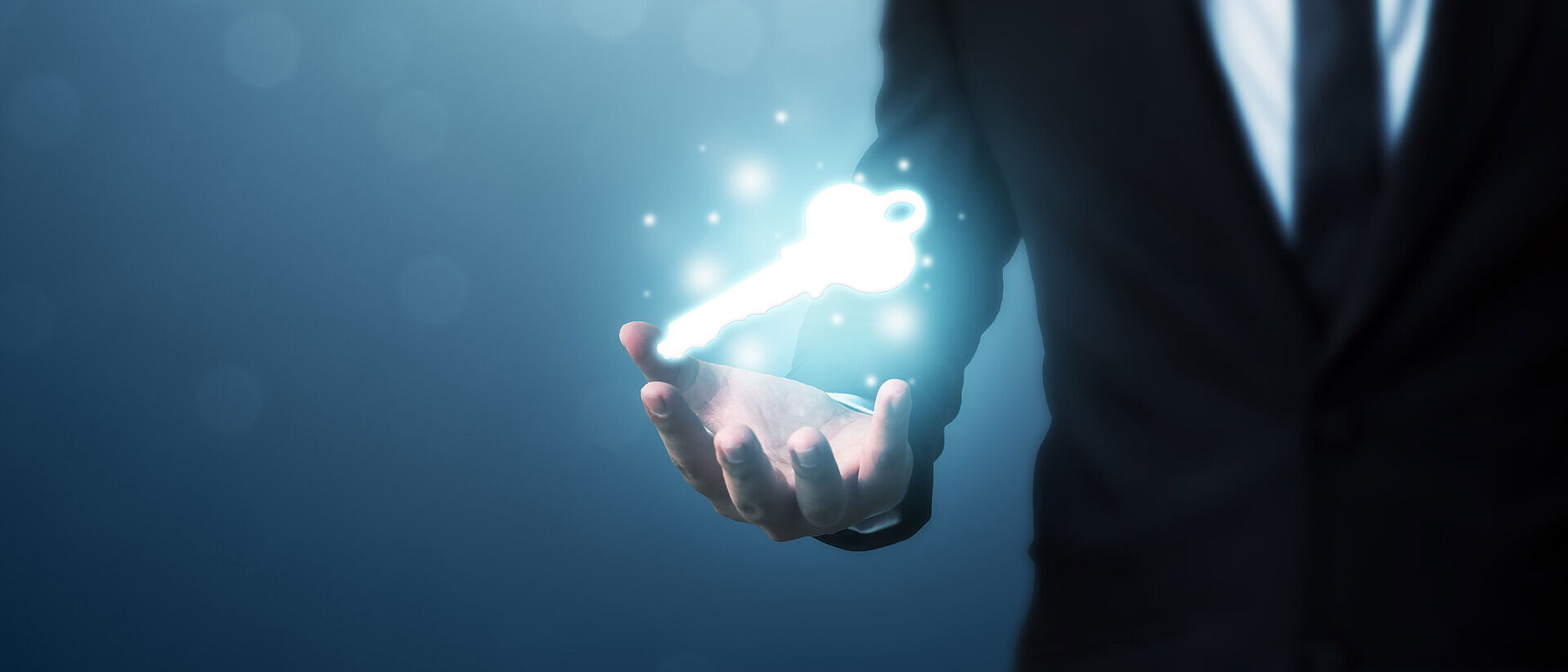 IT security A glowing key hovers above a businessman's hand, symbolizing T Business' IT security solutions.