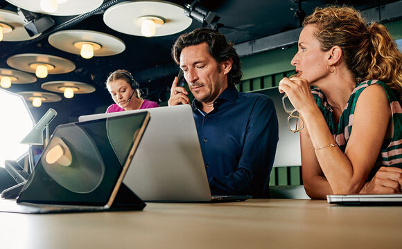 A group of colleagues researching a project on digitalization together on a laptop