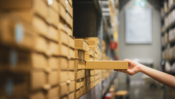 Cloud migration A parcel is sorted onto a shelf in a warehouse visualizing cloud migration, a T Business solution.