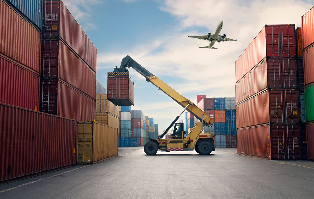 Airplane flies over container port managed with IT Solutions for enterprises