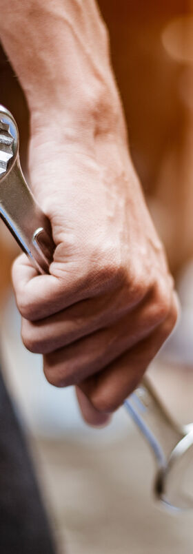 Cloud migration A mechanic holds a spanner in his hand visualizing how to mix and match tools with cloud migration by T Business.