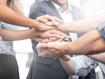 Cloud Computing People put their hands over each other and symbolize the strong partnership between Microsoft and Cloud Computing, a T Business solution.