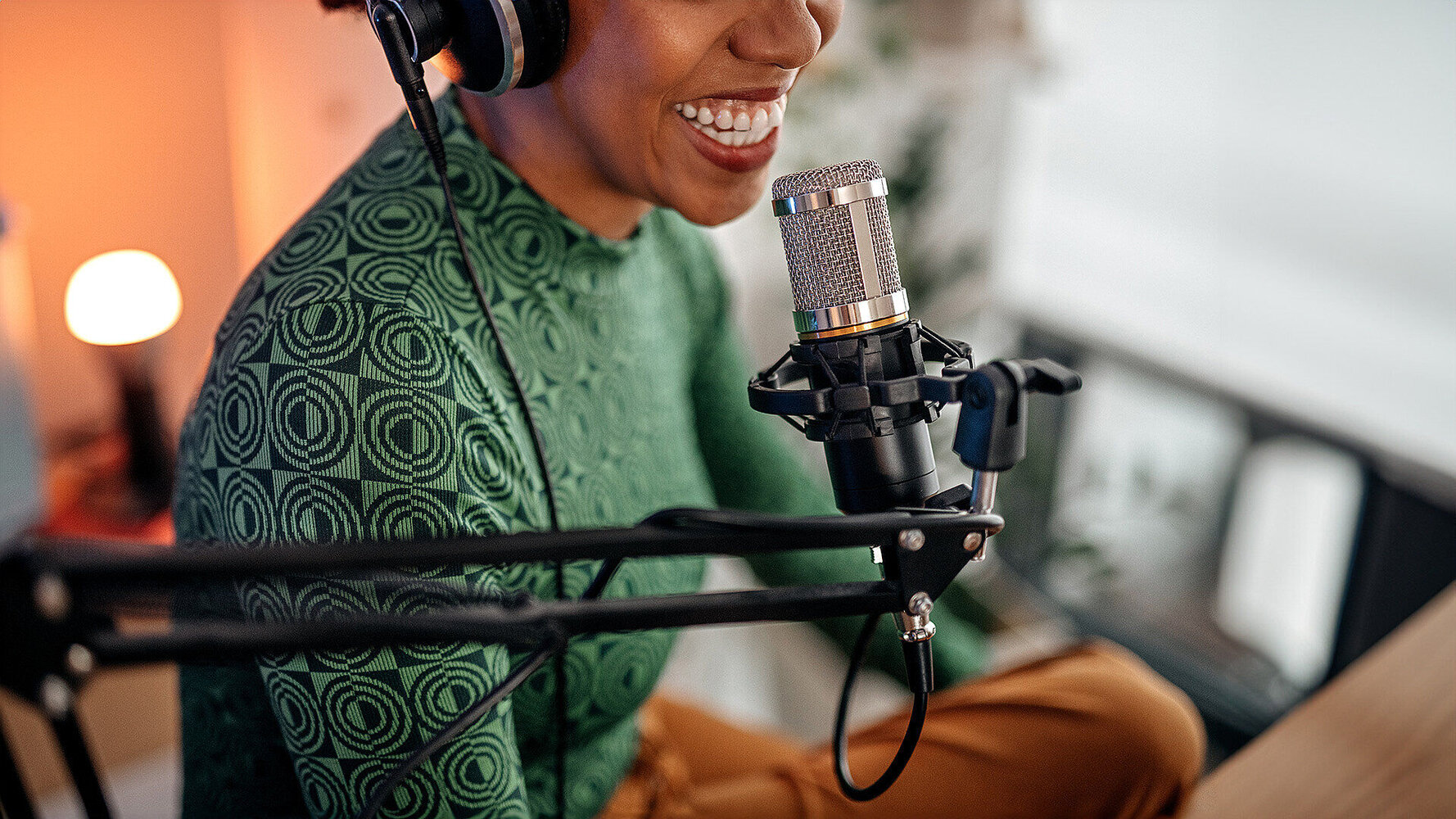 A woman sitting in front of a microphone and doing a podcast to the one from T Business and COSMOTE.