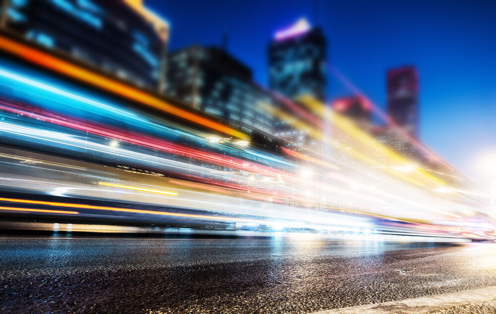 Connectivity solutions Blurred lights of passing cars in a city at night symbolize how internet access can be supercharged with connectivity solutions from T Business.