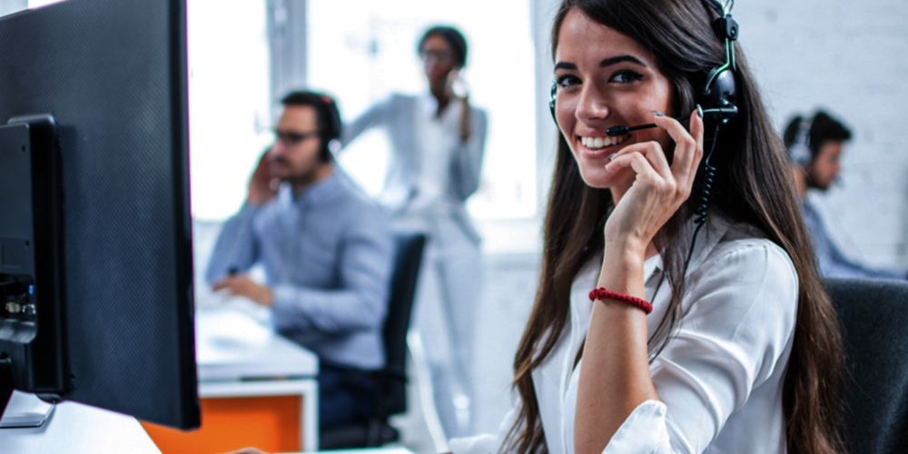Woman with headset sitting in Trenkwalder office using the cloud implemented by T Business.