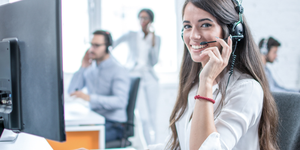 Woman with headset sitting in Trenkwalder office using the cloud implemented by T Business.