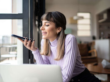 Hospitality IT Solutions A woman talking to her smartphone for the search von hospitality IT solutions