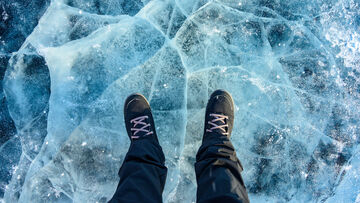 Security risks A person stands on a cracked ice surface as a symbol for penetration testing with T Business solutions to identify security risks.