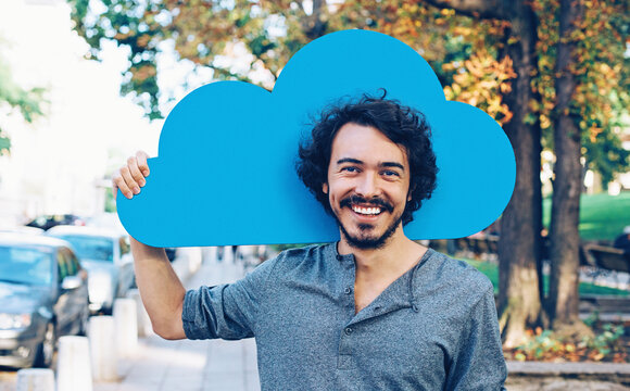 Young man with blue cloud on the street representing cloud computing | T Business
