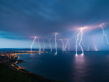 Lightning in the night sky symbolizes sustainable digitalization solutions by T Business that can minimize the risk of water damage from natural disasters.