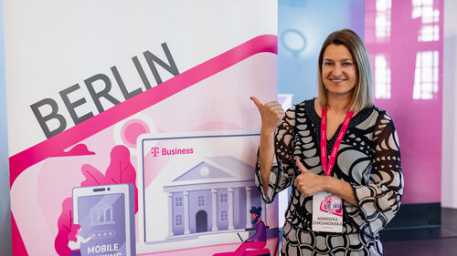 Digital Transformation in Banking & Insurance Industry Woman pointing at the Telekom Business Europe booth at Digital Transformation in Banking & Insurance Industry