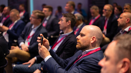 Digital Transformation of Manufacturing Industry A person in the crowd taking a picture of the presentation with his smartphone at Digital Transformation of Manufacturing Industry | T Business