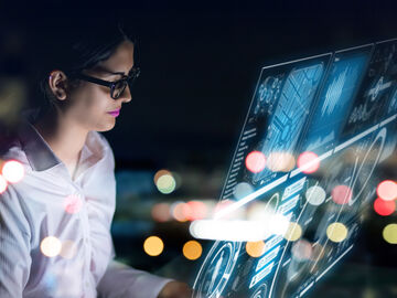A business woman working on a holographic screen with big data analytics tools by T Business.