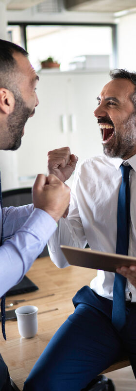 New work A group of business people with a tablet celebrate a success by working with new work solutions for digital workplaces by T Business.