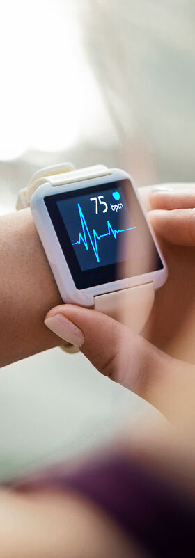 An athletic woman looking at her smartwatch to get e-health data to support her sporty lifestyle thanks to the government's digital transformation