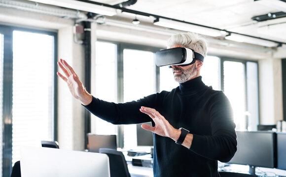 Businessman with virtual reality goggles in the office using managed IT | T Business