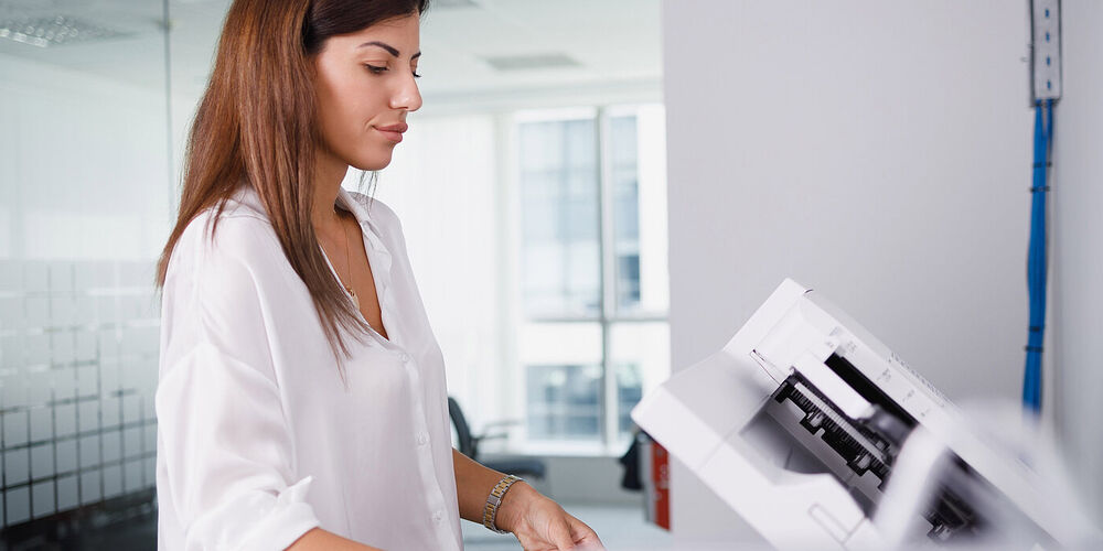 Woman making copies of documents of ICT solutions in Europe