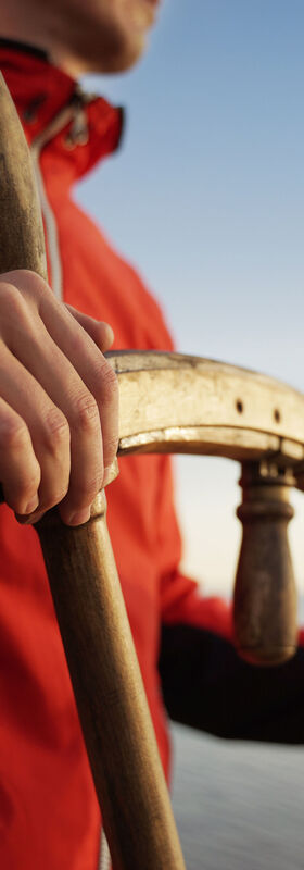 A man holding a ship rudder symbolizes keeping control with the next generation hybrid data center, T Business solution.