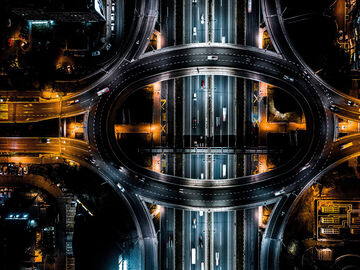 A road overpass with yellow and white streetlights at night in a smart city