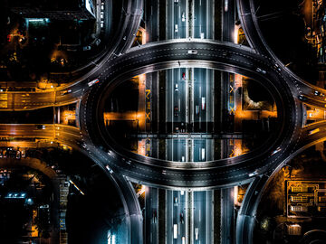 A road overpass with yellow and white streetlights at night in a smart city