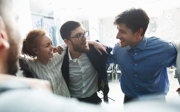 Happy businesspeople bonding in circle celebrating the Cisco partnership | T Business 