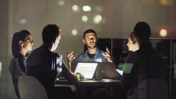 Seamless communication A team of employees is able to work together efficiently on their laptops thanks to seamless communication and collaboration solutions provided by T Business.