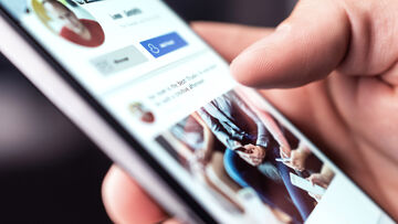 Online Marketing For Small Business A person looking up the online marketing of a small business in their phone | T Business