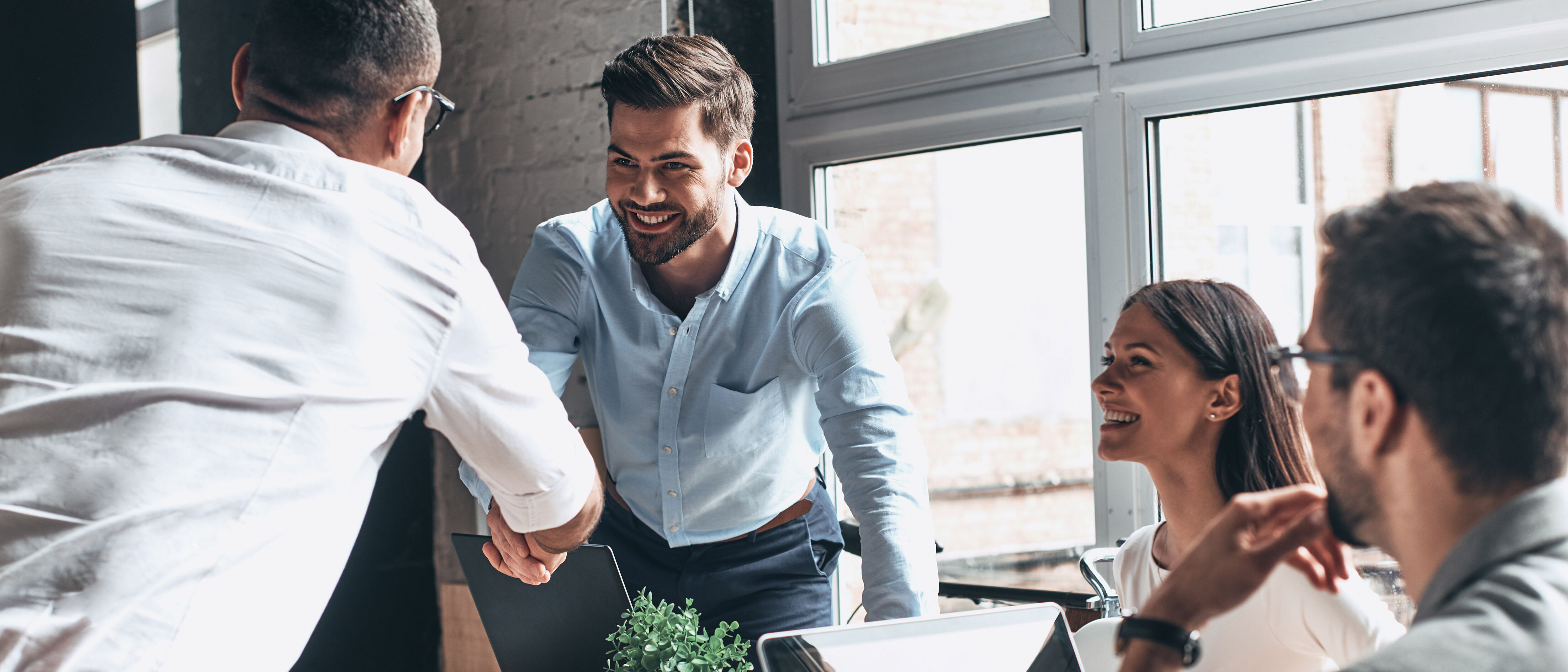 Digitalization A group of business people with laptops and smart devices having a meeting in a modern office and talking about digitalization with T Business.