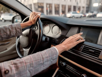 A woman in her car using a parking system in a smart city