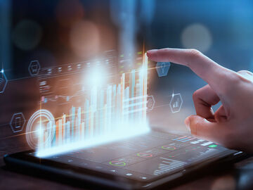 Application modernization Statistics are displayed holographic on a tablet symbolizing cutting edge working with application modernization from T Business.