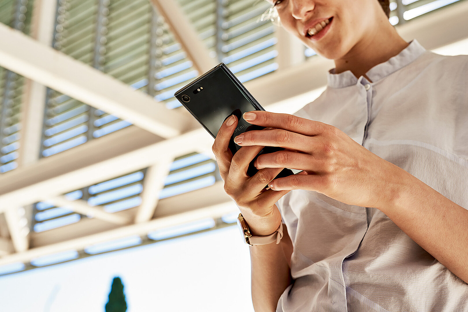 Small Business Communication Platform A woman using her phone to confirm her reservation via chat – made possible by CPaaS from T Business Europe.